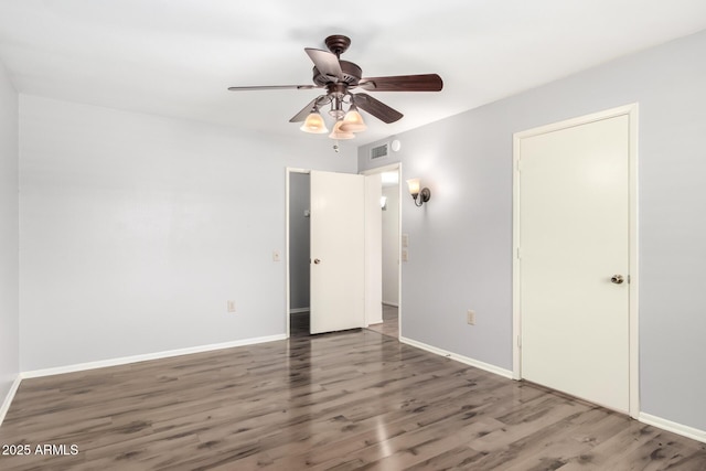 unfurnished bedroom with baseboards, visible vents, wood finished floors, and a ceiling fan