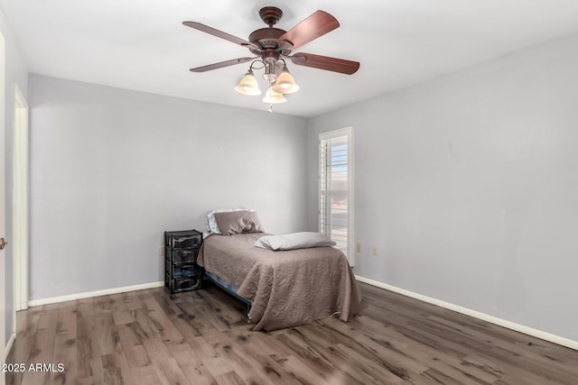 bedroom with baseboards, wood finished floors, and a ceiling fan