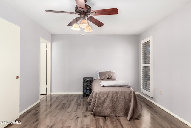 bedroom with baseboards, wood finished floors, and ceiling fan