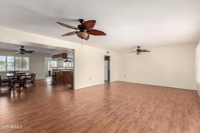 living area with wood finished floors and a ceiling fan