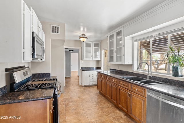 1749 W Monterosa St, Phoenix, AZ 85015 - kitchen with stainless steel appliances, white cabinetry, brown cabinetry, and glass insert cabinets