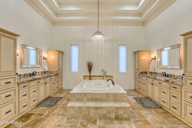 bathroom featuring a high ceiling, a wealth of natural light, tiled tub, and vanity