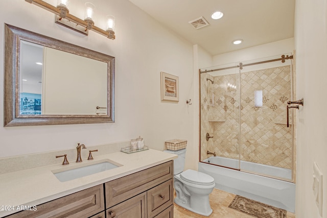 full bathroom featuring bath / shower combo with glass door, vanity, tile patterned flooring, and toilet