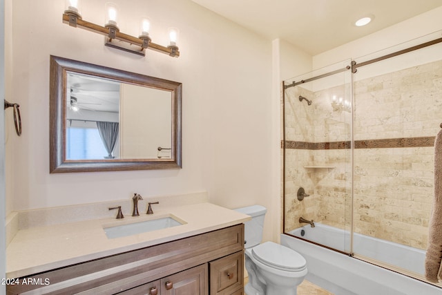 full bathroom with ceiling fan with notable chandelier, bath / shower combo with glass door, toilet, and vanity