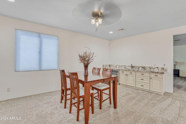 carpeted dining room featuring ceiling fan and sink