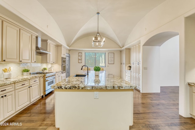 kitchen featuring lofted ceiling, wall chimney range hood, high end stainless steel range oven, and an island with sink