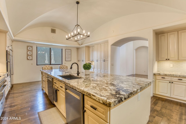 kitchen featuring dark hardwood / wood-style floors, vaulted ceiling, sink, light stone countertops, and an island with sink