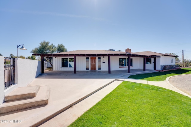 exterior space featuring board and batten siding, a front yard, and fence