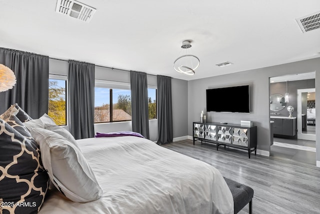 bedroom featuring baseboards, visible vents, and wood finished floors