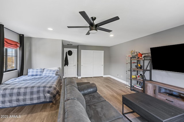 bedroom with baseboards, ceiling fan, wood finished floors, a closet, and recessed lighting