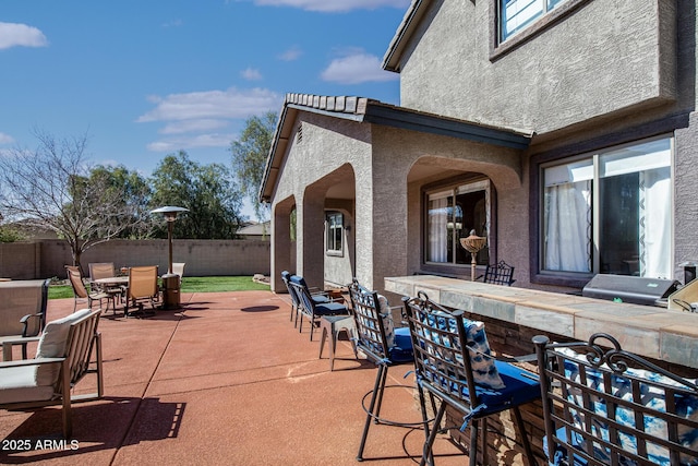 view of patio / terrace with outdoor dry bar, outdoor dining space, and fence