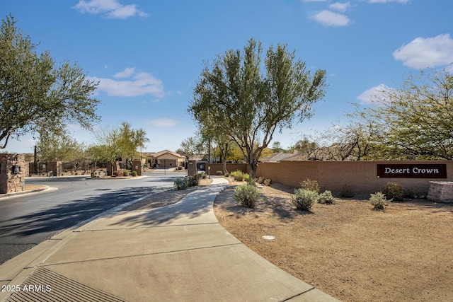 view of road with sidewalks, a gated entry, and curbs