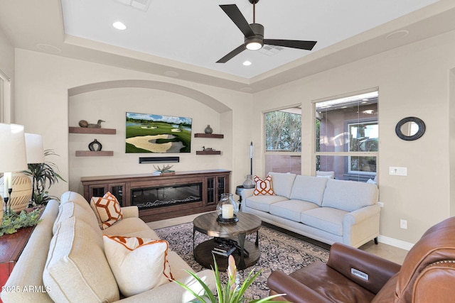 living room featuring a tray ceiling and ceiling fan