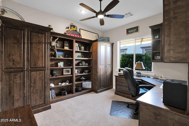 carpeted office space featuring ceiling fan