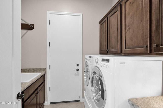 clothes washing area featuring cabinets, washer and clothes dryer, and sink