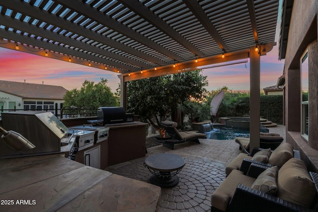 patio terrace at dusk featuring a pergola, grilling area, and exterior kitchen