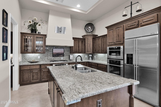 kitchen with a kitchen island with sink, sink, and appliances with stainless steel finishes