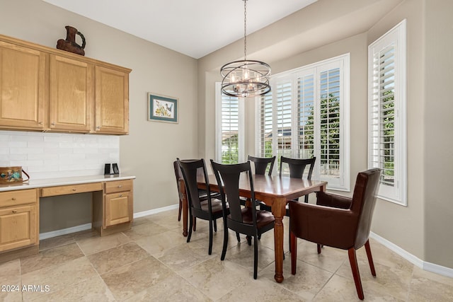 dining room with a notable chandelier, baseboards, and built in desk