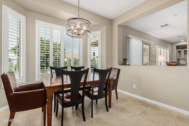 dining space with a chandelier, visible vents, and baseboards