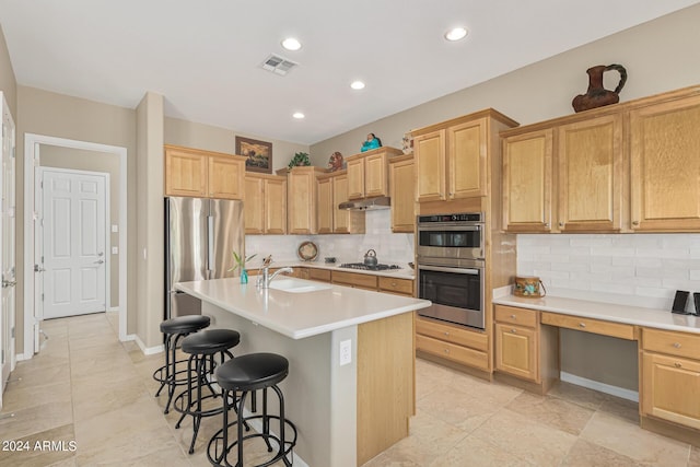 kitchen with under cabinet range hood, visible vents, light countertops, appliances with stainless steel finishes, and a center island with sink