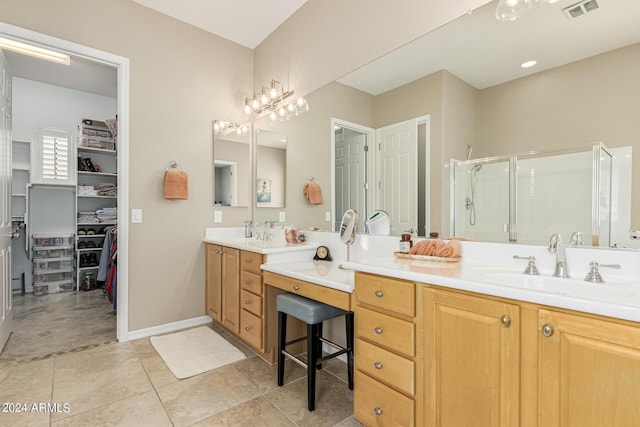 bathroom featuring a walk in closet, visible vents, a shower stall, vanity, and baseboards