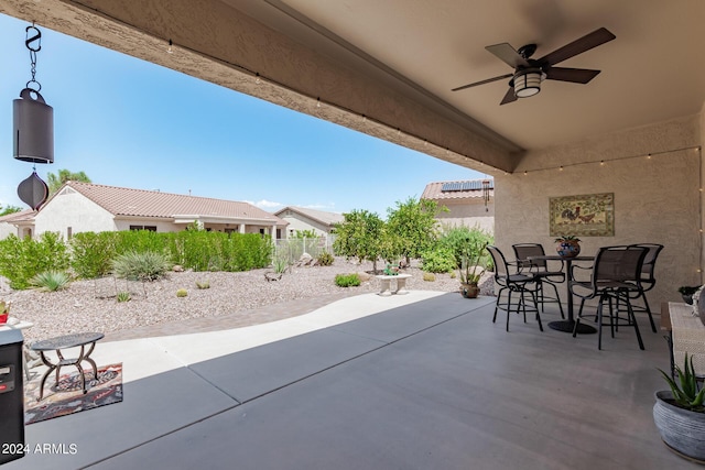 view of patio featuring a ceiling fan, outdoor dining area, and fence