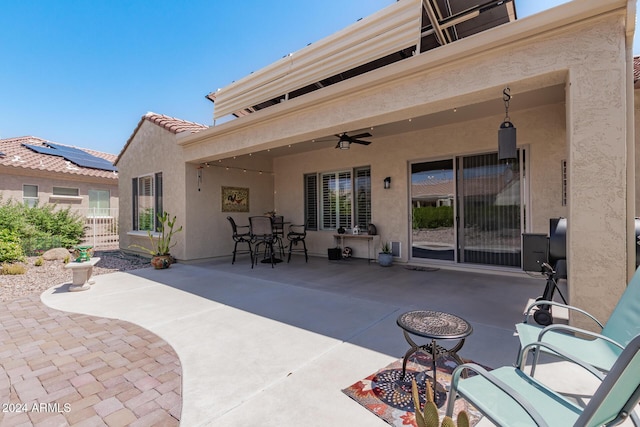 back of house featuring a tile roof, a patio, stucco siding, ceiling fan, and fence