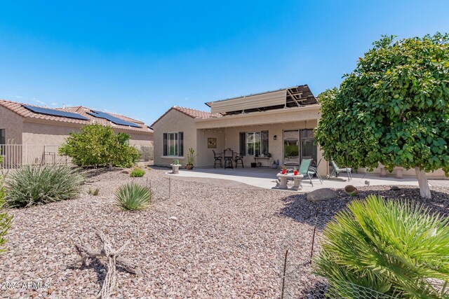 rear view of house with a patio, fence, and stucco siding