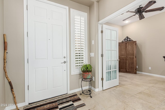 foyer with ceiling fan and baseboards