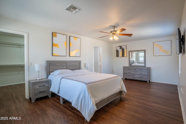 8516 N 64th Ave, Glendale, AZ 85302 - bedroom with dark wood-style flooring, a walk in closet, baseboards, a ceiling fan, and a closet