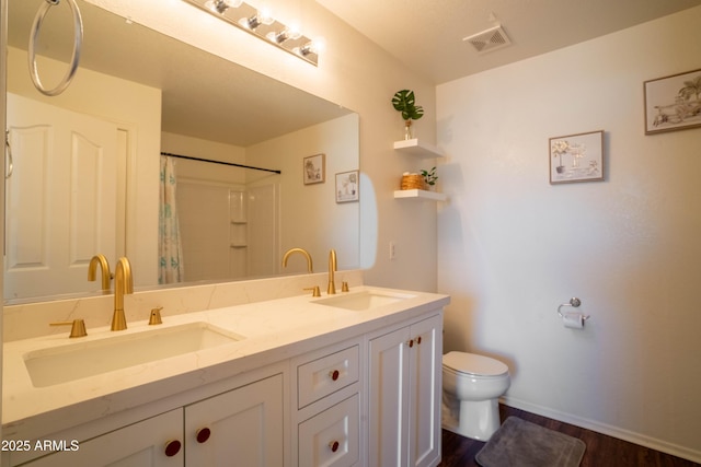 8516 N 64th Ave, Glendale, AZ 85302 - full bathroom featuring toilet, wood finished floors, double vanity, baseboards, and a shower with shower curtain