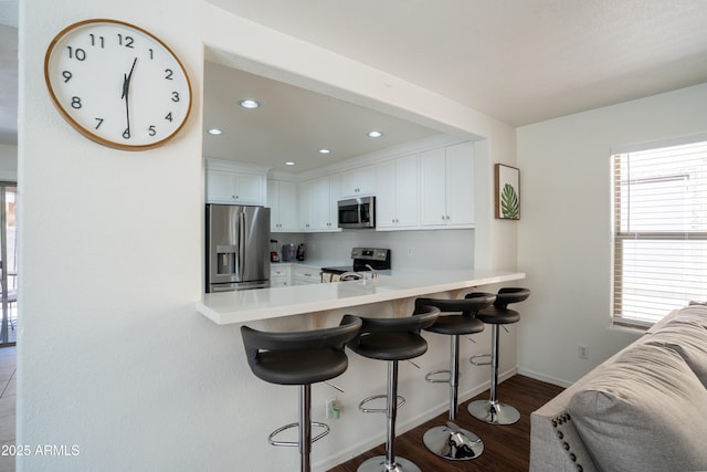 8516 N 64th Ave, Glendale, AZ 85302 - kitchen with stainless steel appliances, light countertops, white cabinets, dark wood-style flooring, and recessed lighting