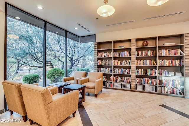 living area featuring expansive windows and light tile patterned flooring