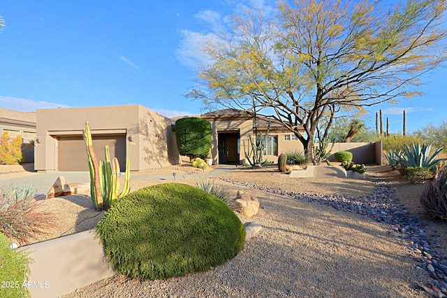 pueblo revival-style home featuring a garage