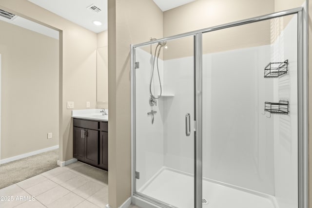 bathroom featuring tile patterned floors, a shower with door, and vanity