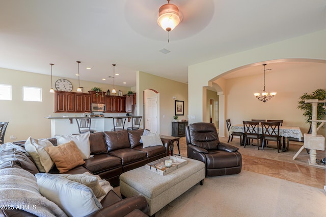 living area featuring arched walkways, an inviting chandelier, and recessed lighting
