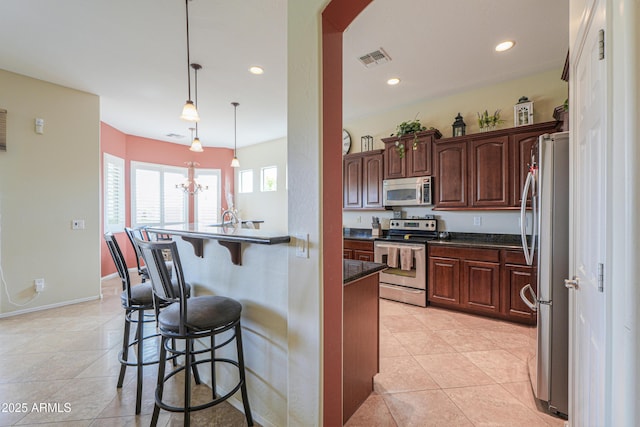 kitchen with a kitchen breakfast bar, recessed lighting, light tile patterned floors, visible vents, and appliances with stainless steel finishes
