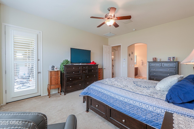 bedroom featuring access to outside, light carpet, ensuite bathroom, visible vents, and arched walkways