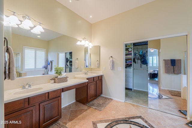 bathroom with a sink, tile patterned floors, baseboards, and double vanity