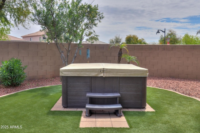 view of yard featuring a fenced backyard and a hot tub