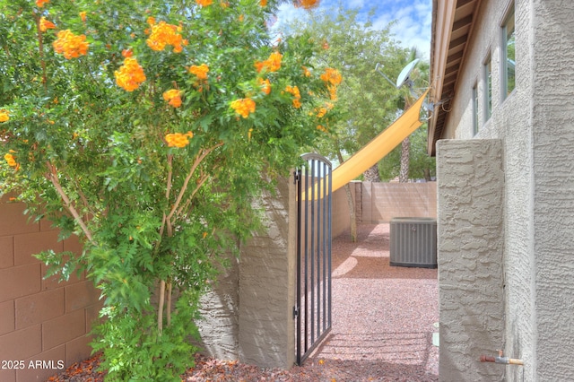 view of gate featuring central AC and fence