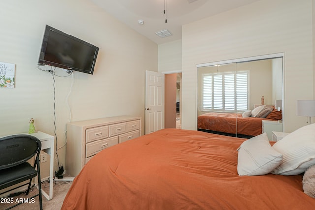 bedroom with carpet flooring, visible vents, a closet, and lofted ceiling