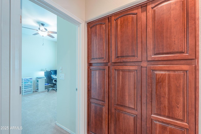 hallway with baseboards and carpet flooring
