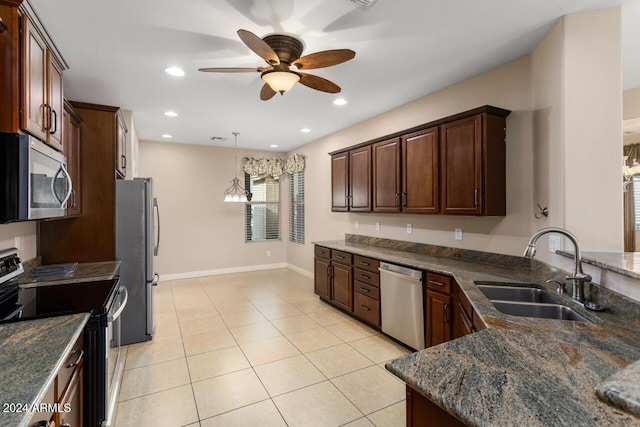 kitchen with dark stone counters, sink, hanging light fixtures, ceiling fan, and stainless steel appliances