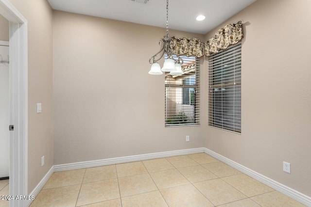 unfurnished dining area with a chandelier and light tile patterned floors