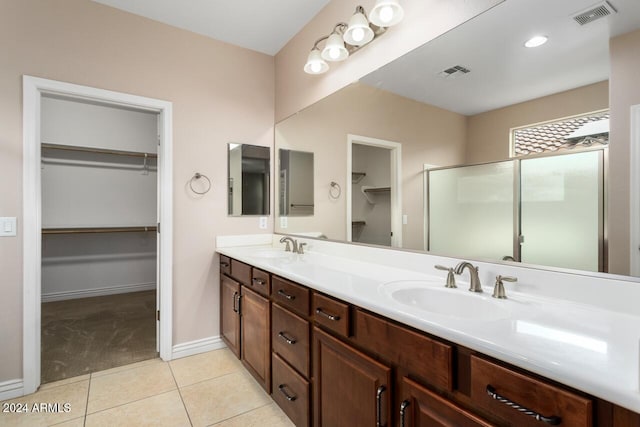 bathroom with tile patterned flooring, vanity, and walk in shower