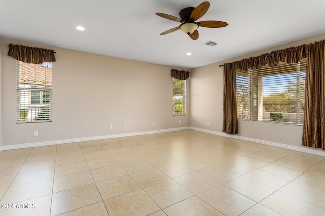 unfurnished room featuring a wealth of natural light, ceiling fan, and light tile patterned flooring