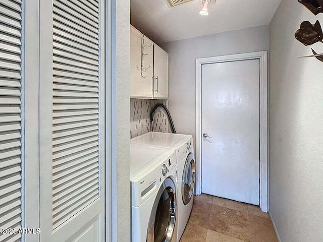 laundry room with washing machine and dryer and cabinets