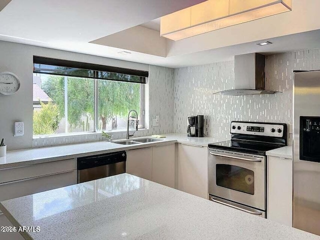 kitchen with a healthy amount of sunlight, appliances with stainless steel finishes, sink, and wall chimney exhaust hood