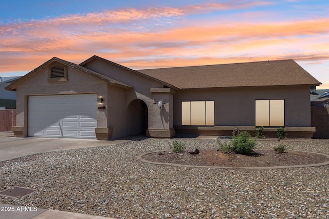 view of front of house featuring driveway, stucco siding, an attached garage, and roof with shingles